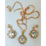 A blue topaz pendant set oval topaz, in 9ct gold scroll mount, on 9ct gold neck chain, with matching