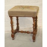 An antique fruit wood stool, the needlework seat on turned legs and stretcher, 54cm high.