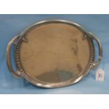 A Tudric polished pewter oval two-handled tray with raised border decoration, stamped marks beneath,