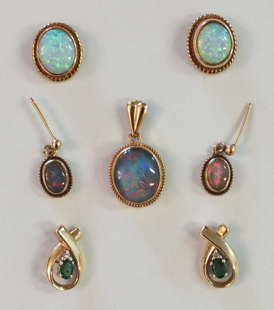 A pair of opal earrings with yellow metal mounts, a pair of black opal doublet earrings and matching