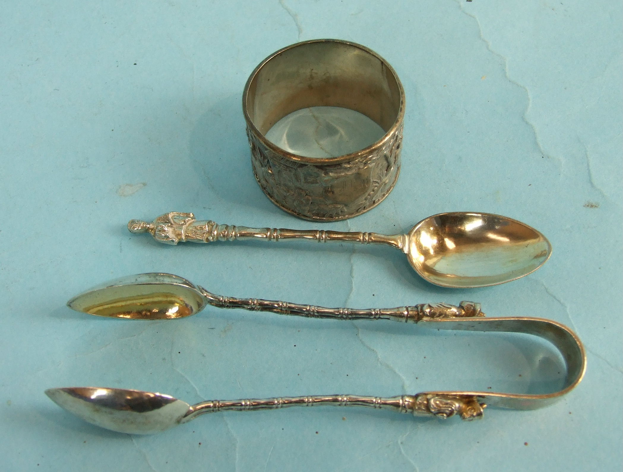 A pair of Wang Hing Chinese sugar tongs, a matching teaspoon and a napkin ring.