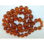 A single row of 47 graduated spherical honey-coloured amber beads, smallest 11mm, largest 19mm, 72.
