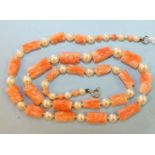 A necklace of alternate carved pink coral batons and cultured pearls, 50cm.