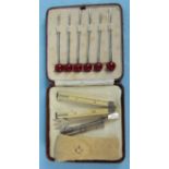 A cased set of six silver cocktail sticks, Birmingham 1932, a miniature silver pickle fork, a