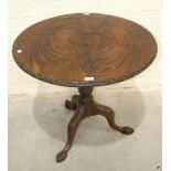 An 18th century mahogany tripod table stem, with leaf-carved legs, claw feet and later circular top,