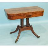 A Regency mahogany fold-over card table, the baize-lined top above a brass-inlaid frieze, raised