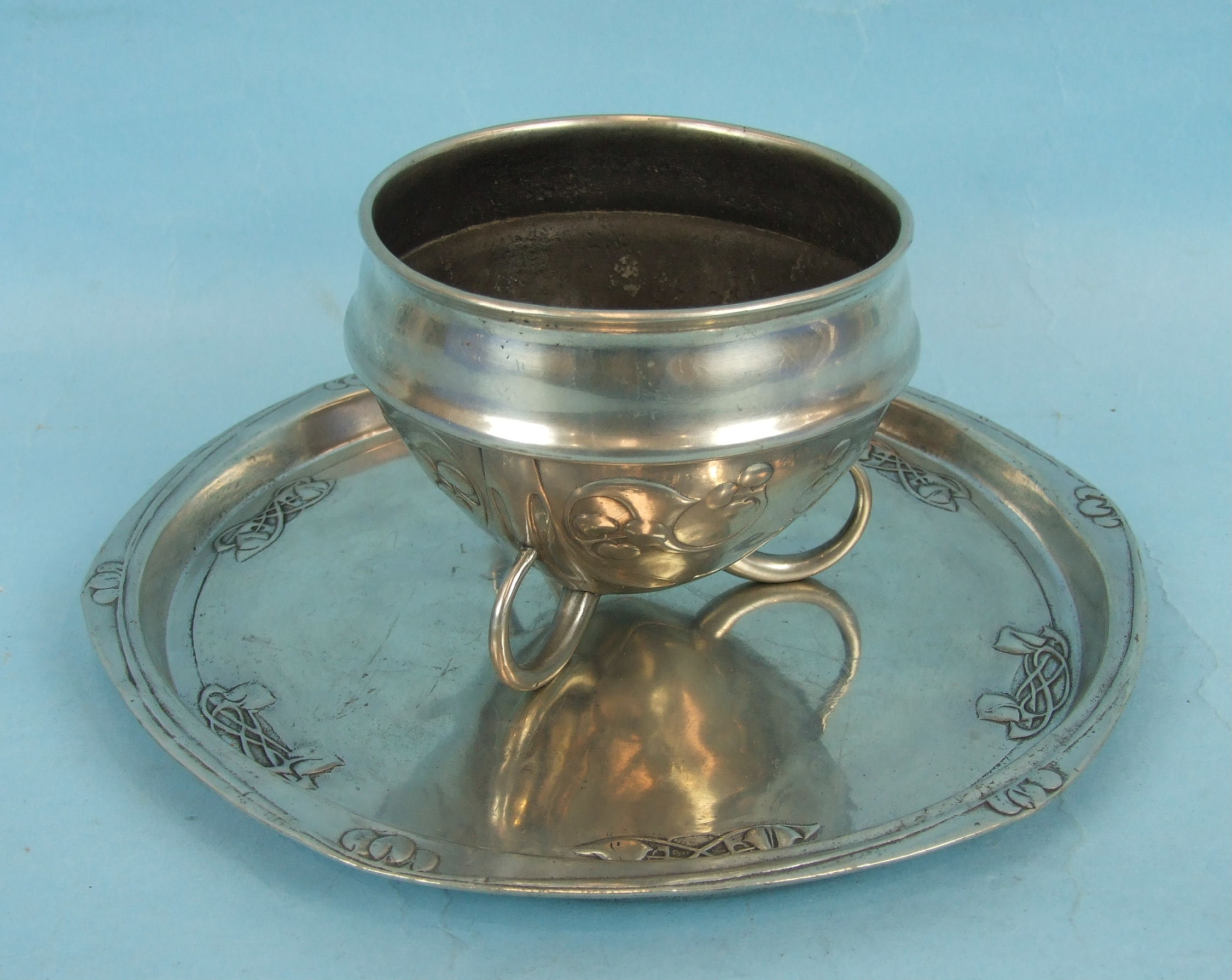 A Liberty & Co. English Pewter circular tray with raised decoration to the border, 26cm diameter,