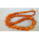 An amber necklace of forty-one graduated butterscotch amber ovoid beads, 2.5cm - 0.8cm long, 63.2g.