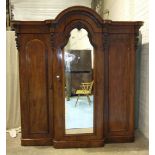 A Victorian mahogany break-front wardrobe, the arched central mirrored door enclosing drawers