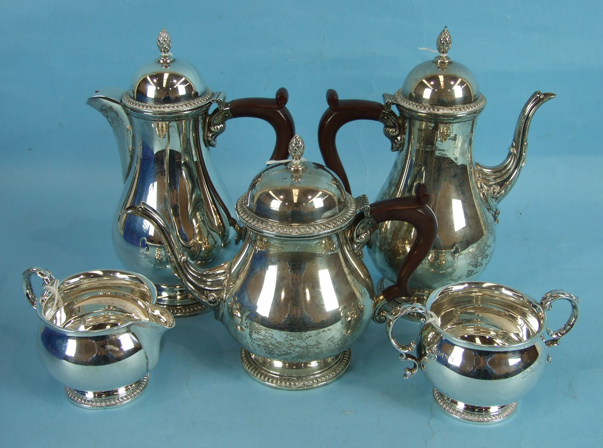 A silver five-piece tea and coffee service of baluster form with scroll spouts and pineapple