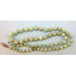 A jade necklace of sixty graduated spherical beads, graduating from 5mm to 9.5mm approximately, 54cm