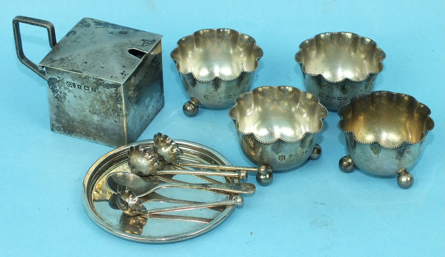 A set of four Victorian silver salts with wavy beaded rims and three matching spoons, Birmingham