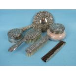 A six-piece silver dressing table set by W I Broadway & Co, the repousse decoration in a design of