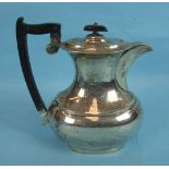 A silver hot water jug of plain oval bellied form with ebony handle and finial, Sheffield 1937, 22cm