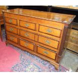 An antique mahogany banded oak "Lancashire chest", the lift lid above three false drawers, a long