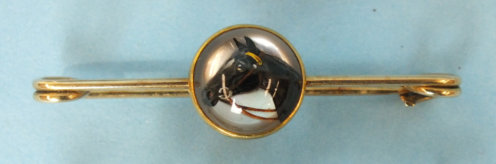 A 19th century reverse intaglio brooch depicting a horse's head with white blaze, on yellow metal