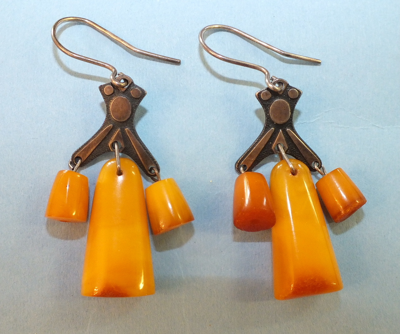 A pair of Russian amber earrings, each with three amber drops below metal mount, bearing Russian 875