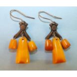 A pair of Russian amber earrings, each with three amber drops below metal mount, bearing Russian 875