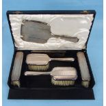 A six-piece engine-turned dressing table brush set in fitted case.