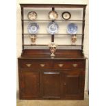 An 18th century oak dresser base, the rectangular top above two frieze drawers, a pair of fielded