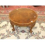 A walnut circular coffee table on four carved wood legs, with claw and ball feet, 74cm diameter,