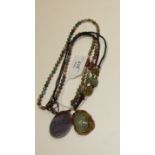 A modern green and brown nephrite-type carved hardstone pendant on plaited cord and a lavender-