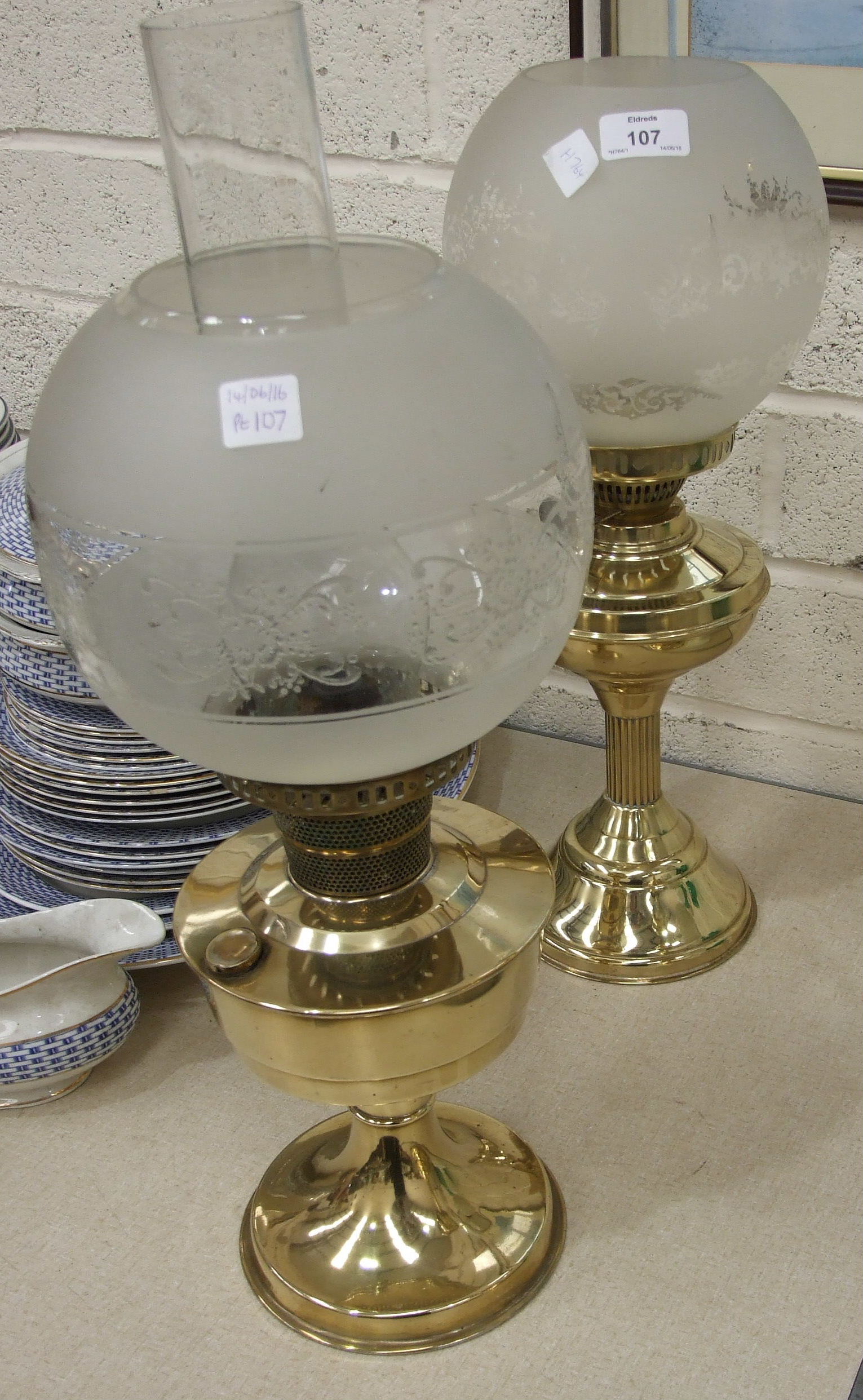 Two brass oil lamps, each with globular etched white and opaque glass shades, 55cm and 53cm overall,