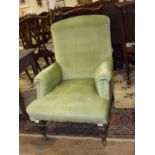 A late Victorian/early 20th century upholstered armchair on turned wood front legs, (af).