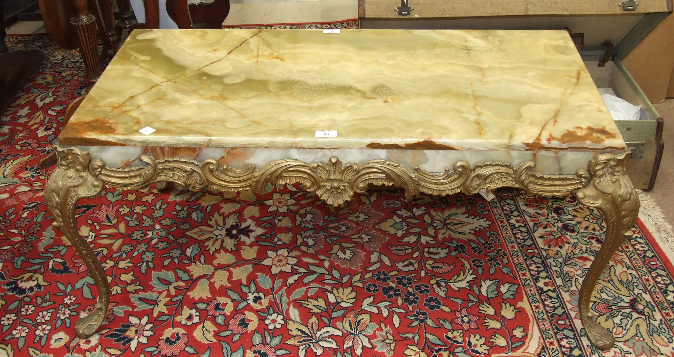 A brass framed onyx topped coffee table with scrolling decoration and cabriole legs, 107 x 56 x 45.