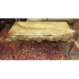 A brass framed onyx topped coffee table with scrolling decoration and cabriole legs, 107 x 56 x 45.