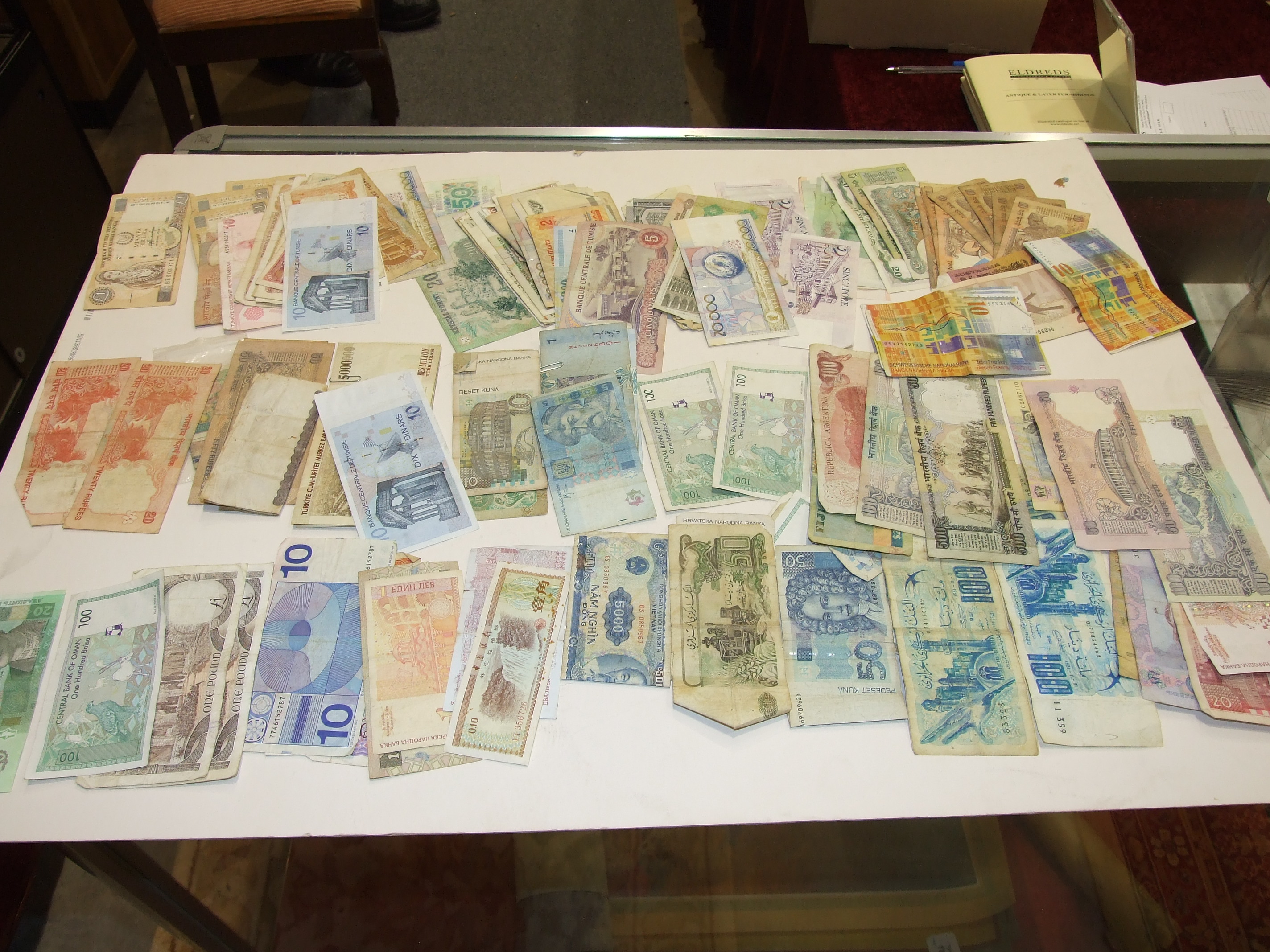 A collection of various foreign bank notes.