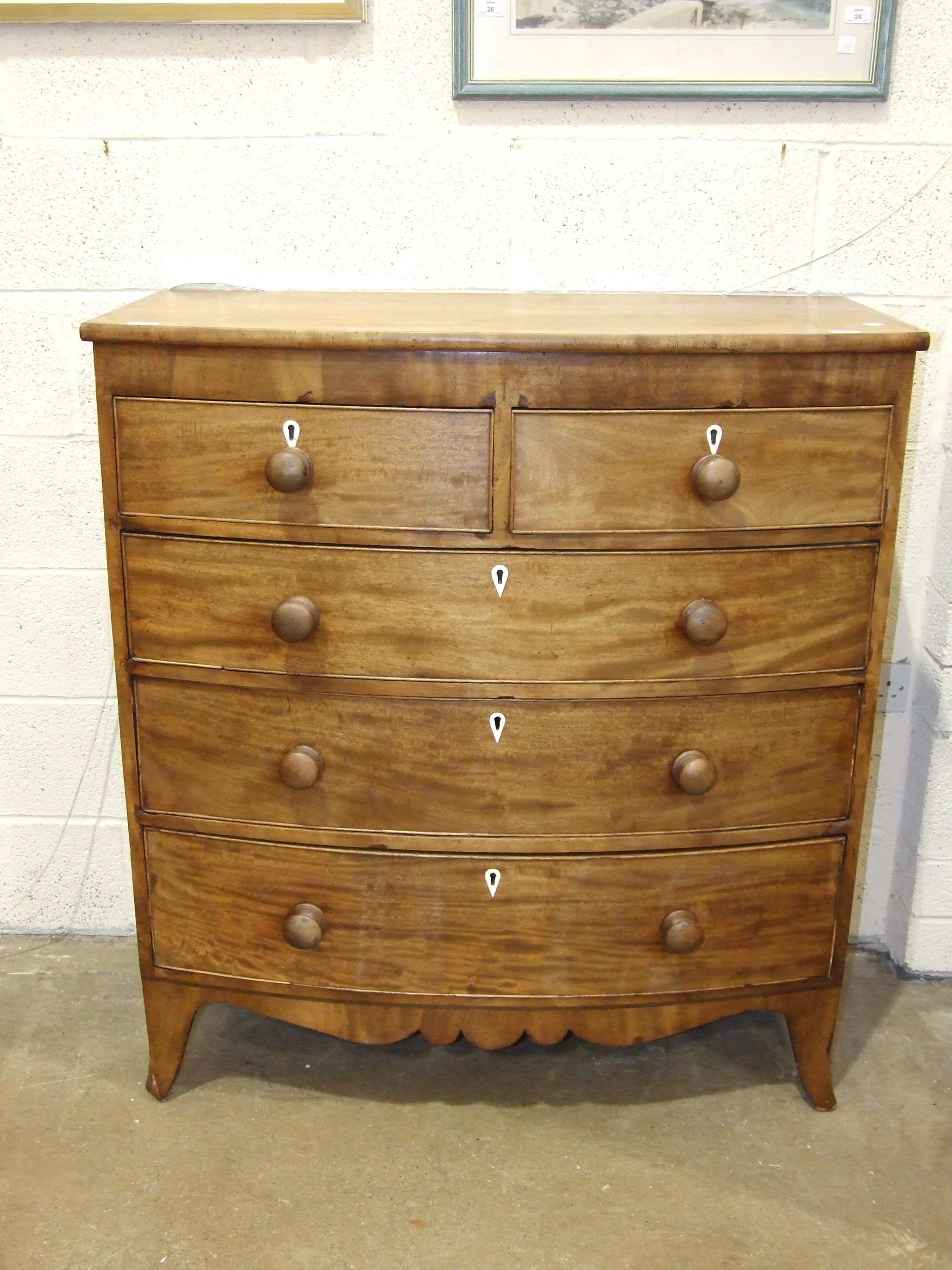 A Georgian mahogany bow-front chest of two short and three long cock-beaded drawers, on splay