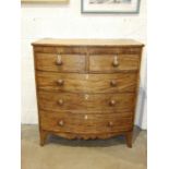 A Georgian mahogany bow-front chest of two short and three long cock-beaded drawers, on splay