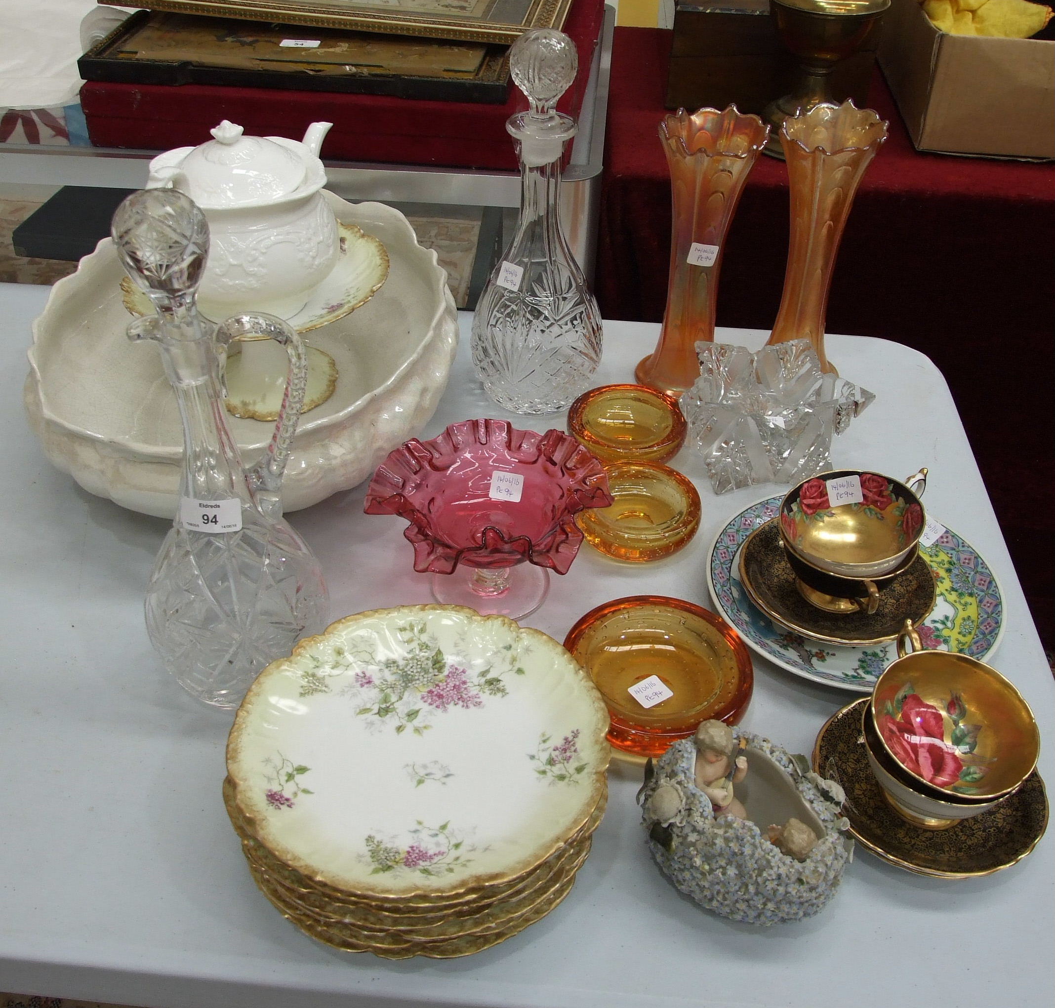 A cut glass jug and stopper, 36cm high, a glass decanter, a cranberry glass dish with wavy rim on