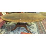 A large good quality reproduction mahogany and rosewood-banded oval dining table on four columns,