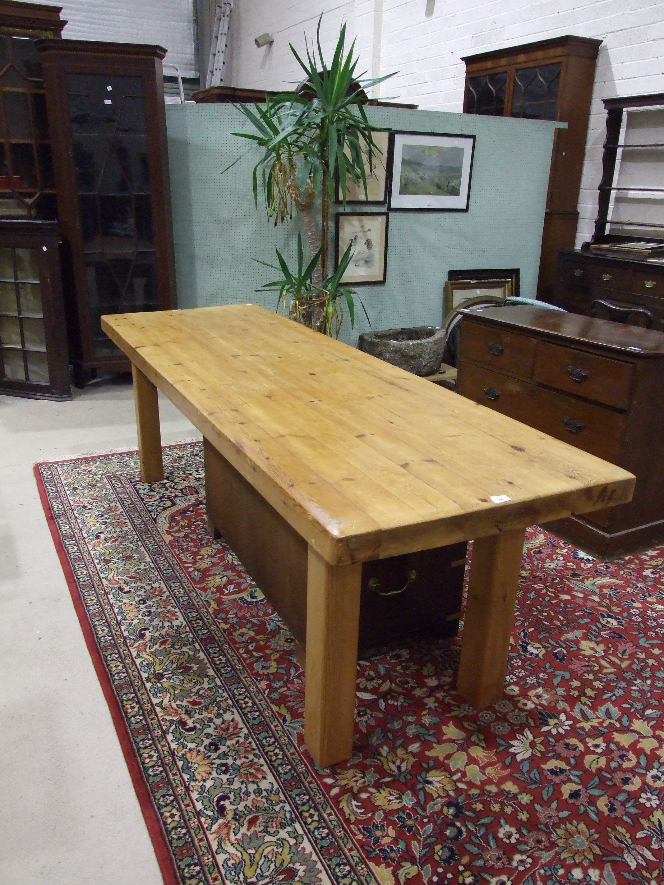 A large and heavy pine kitchen table on plain square legs, 74 x 235cm.