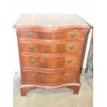 A reproduction mahogany finish low chest, the serpentine top above four graduated drawers, on