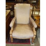 An Edwardian stained wood salon chair with upholstered seat, back and arms, on turned front legs.