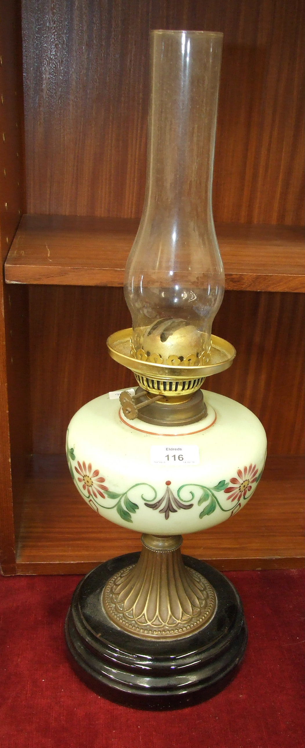 A late-Victorian oil lamp, the green opaque glass reservoir on brass base and circular ceramic