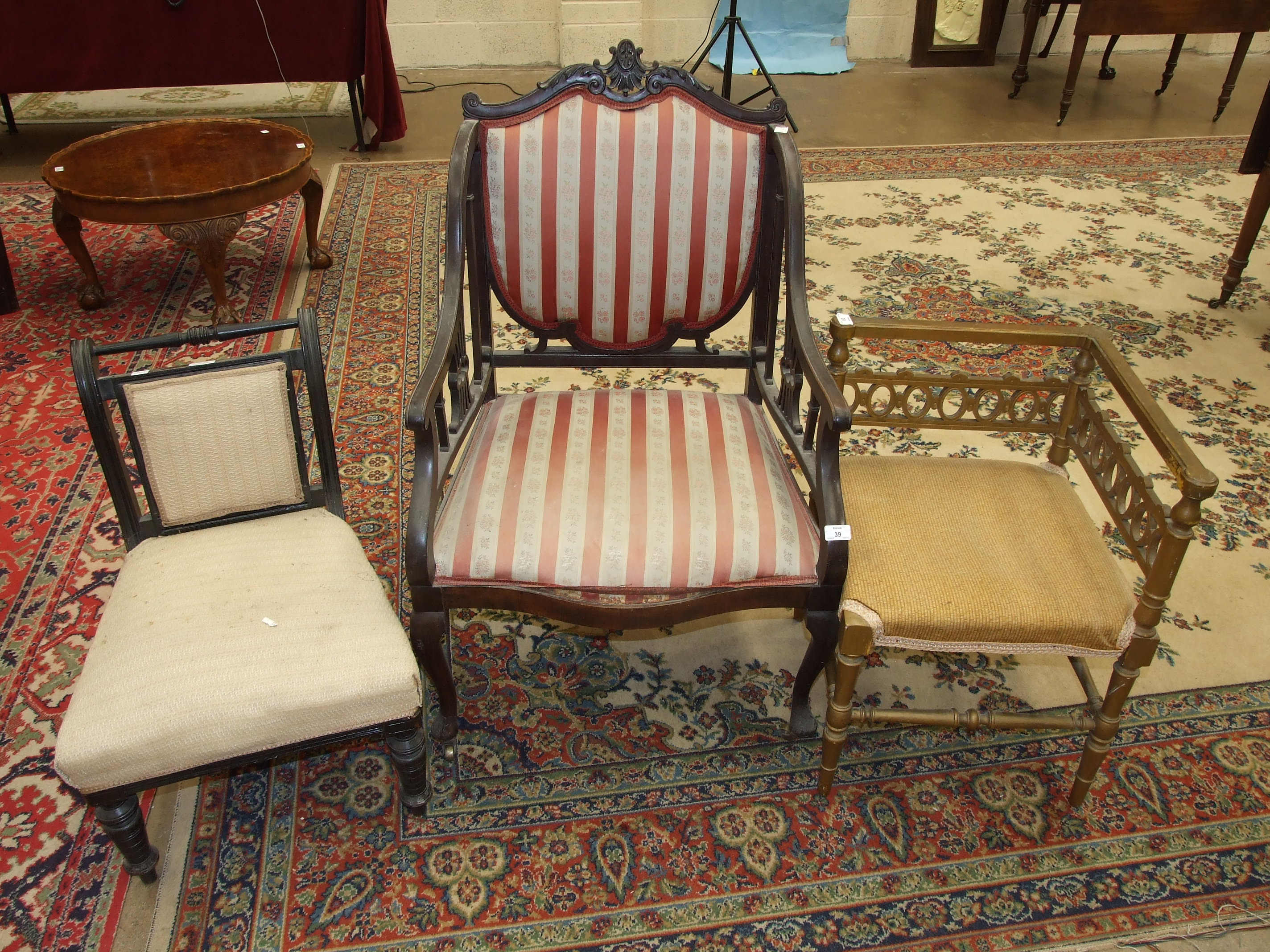 An Edwardian stained mahogany salon chair with upholstered shield back and serpentine seat, on
