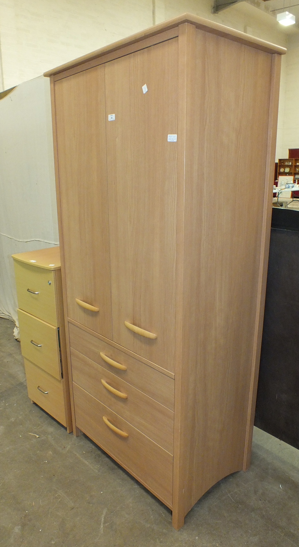 A modern wood finish three-drawer filing cabinet and a modern teak finish wardrobe, (2).