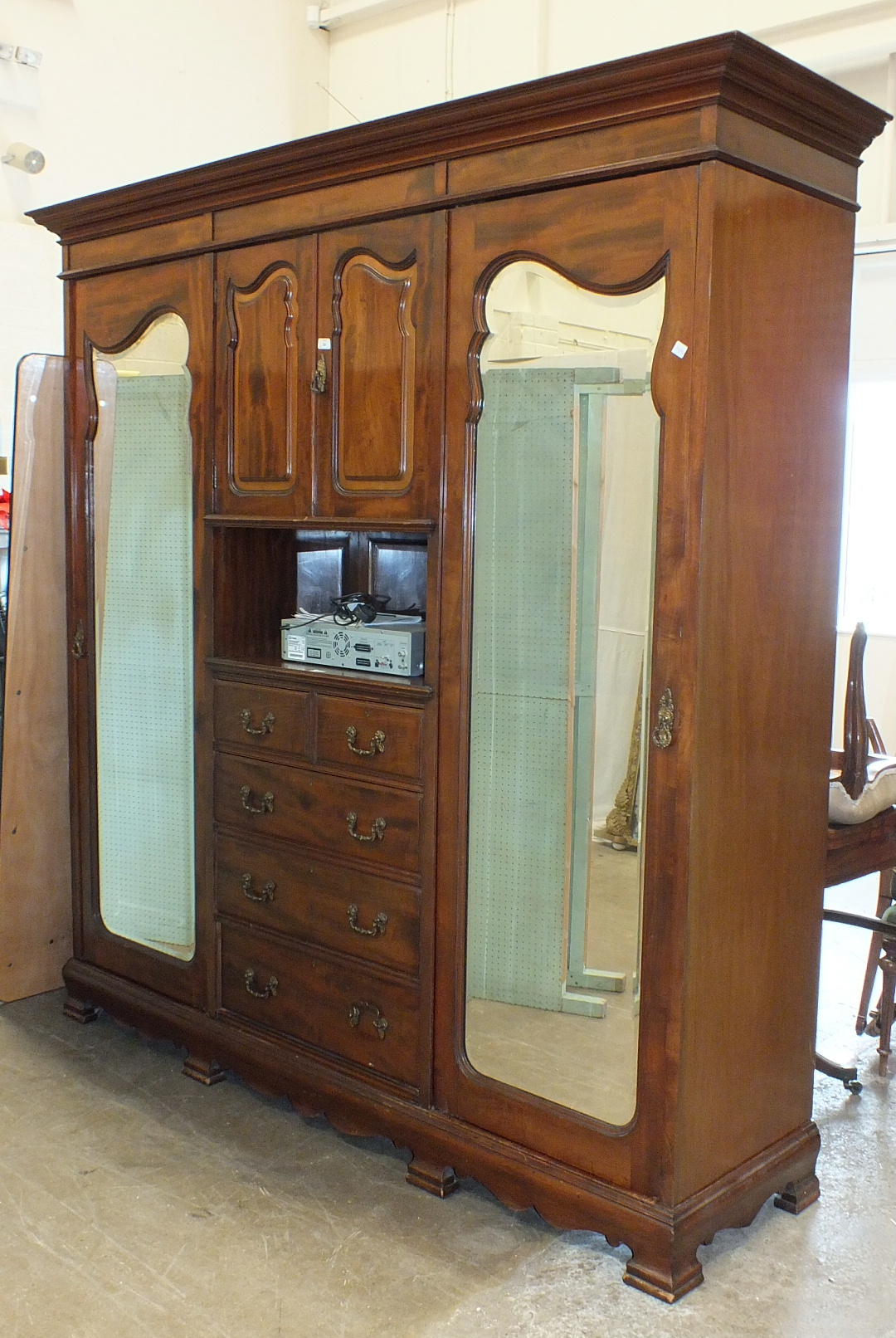 A late-19th/early-20th century mahogany sectional wardrobe, the cornice above a pair of central