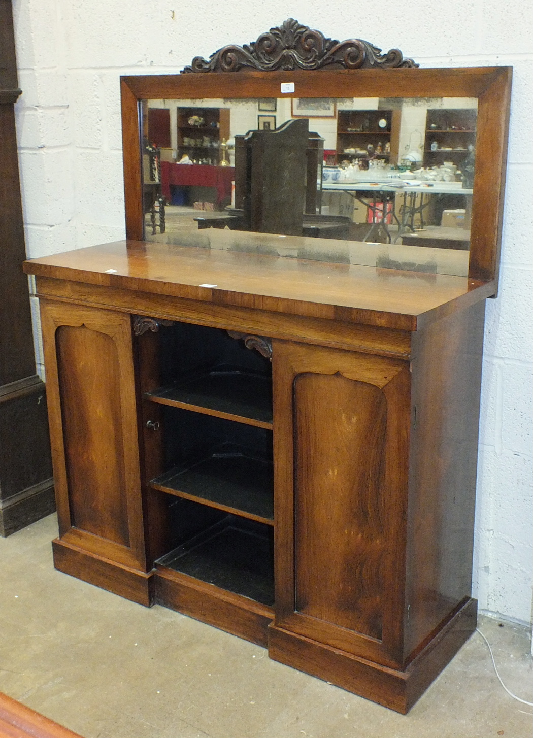 A late-19th century walnut chiffonier, the mirrored back above a rectangular top, with central