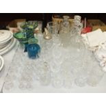 Four glass decanters, a pair of blue and green swirl vases, various wine and drinking glasses.
