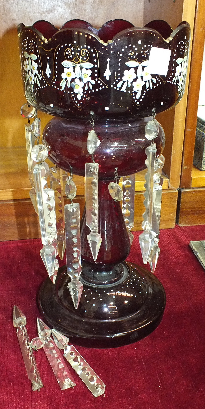 A Victorian ruby glass lustre vase with white, yellow and green enamel floral decoration and clear