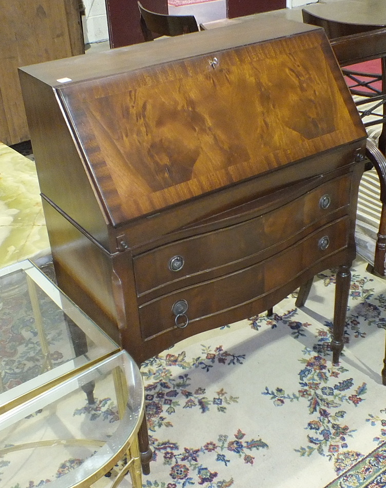 A modern mahogany finish bureau, the fall front above two drawers, on reeded legs, 74.5cm wide and a