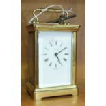 A brass carriage clock, the white enamel dial with Roman numerals, marked 'Henley, Made in England'.