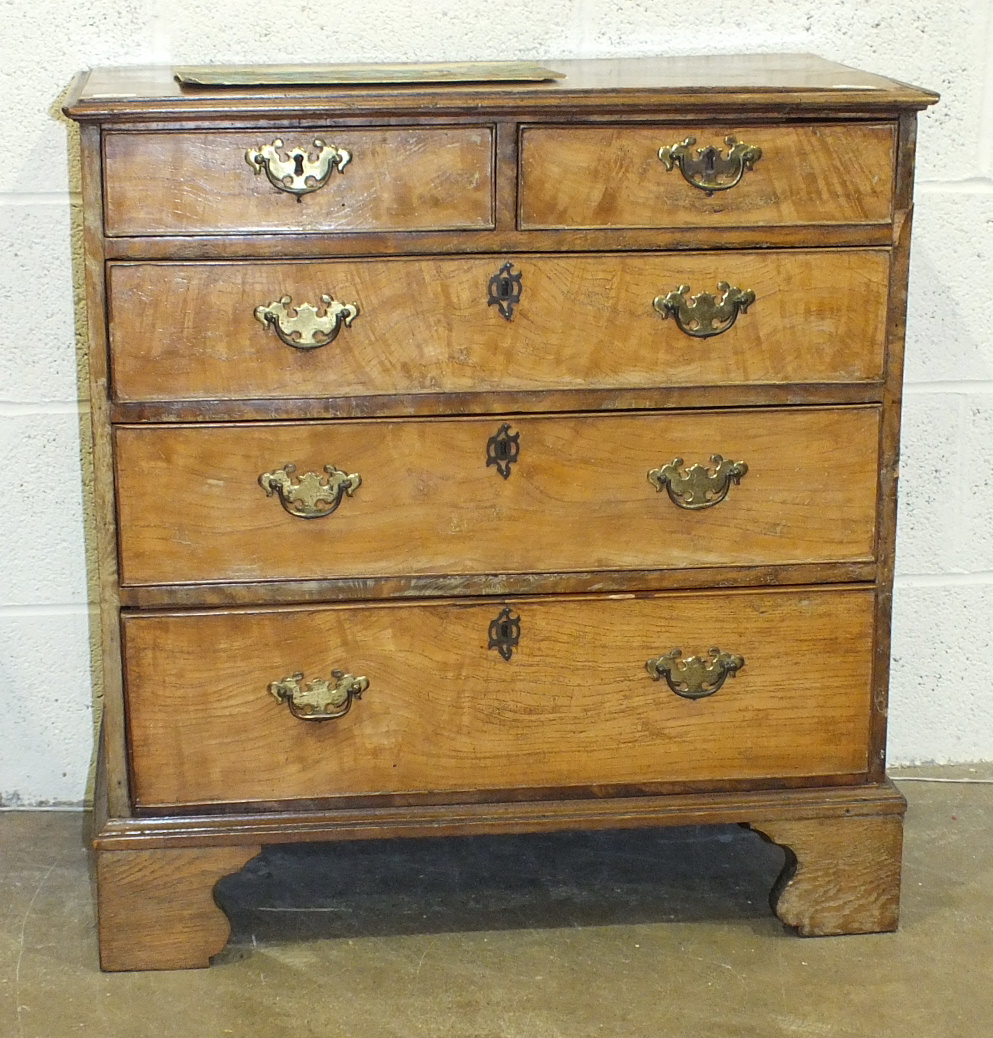 A Georgian elm chest of two small and three long cockbeaded drawers, on bracket feet, with later