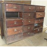 An early-20th century rack of fifteen pine drawers, (two lacking), 216cm wide, 157cm high.