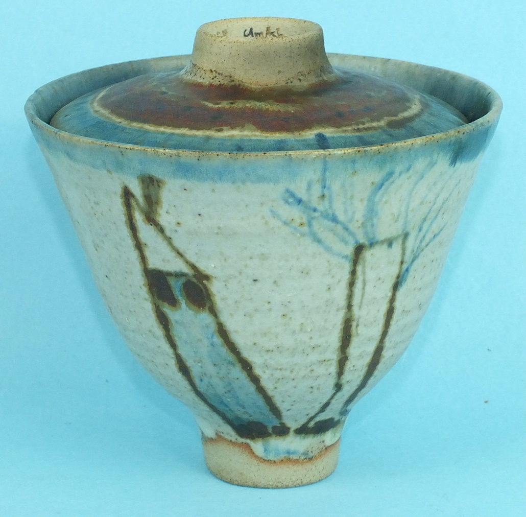 A studio pottery bowl and cover decorated with stylised landscapes and figures, signed 'E J